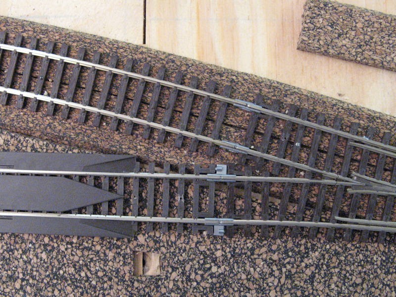 Two different types of block insulators following a set of points. Note the re-railer again to the left.