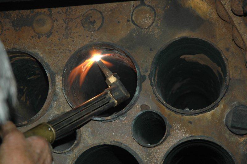 John Dadford starts cutting grooves in the large tube so that it can be collapsed prior to removal.