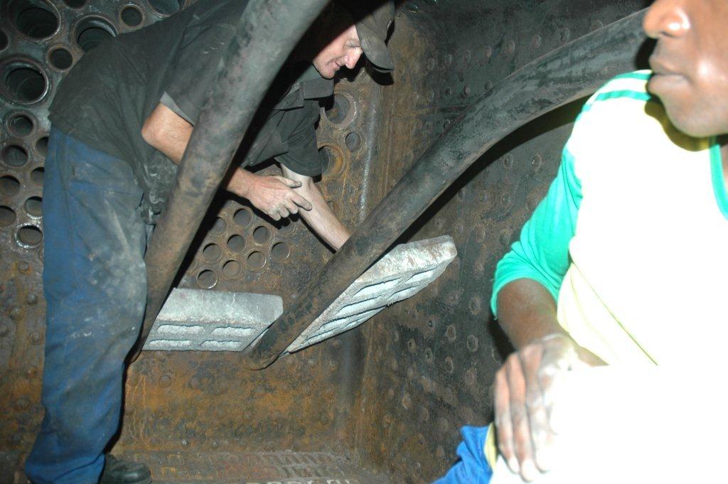 Spikkels does his masonry work while Lloyd passes the bricks to him