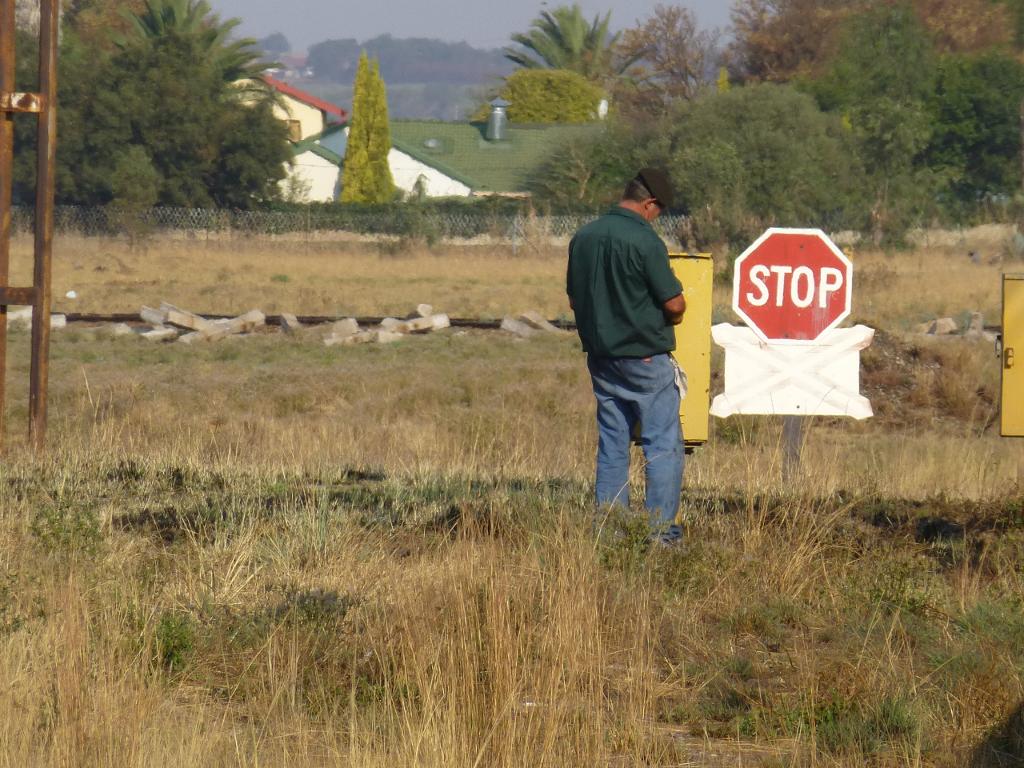 Whatever you may think it looks as if he is doing, Les is actually replacing the wooden train staff in its yellow box at Rayton. Possession of the staff gives authority for a train to enter the Cullinan branch; no other train can then enter without the staff.