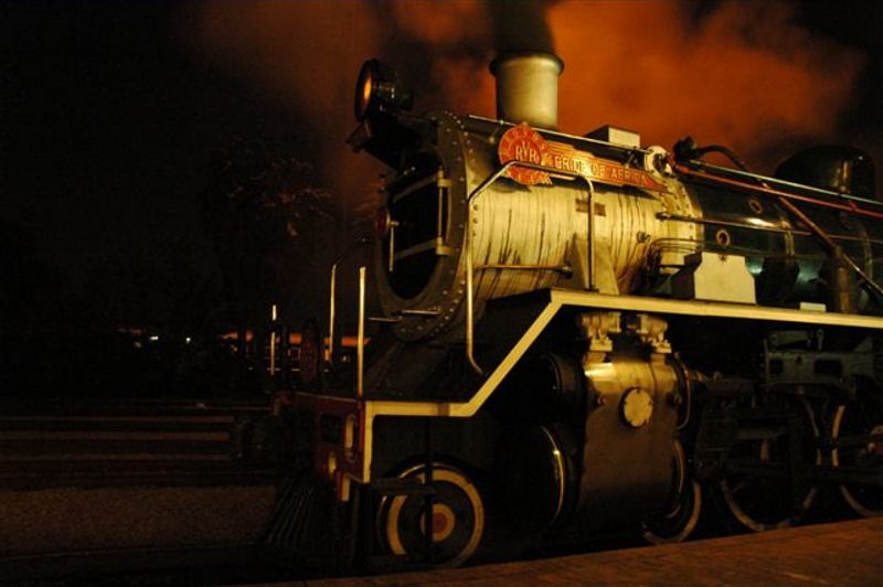 Standing waiting passengers, prior to the dinner run, we find the shed<br />lights creating unusual effects on the Rovos Rail 19D 3360. 26th April 2007