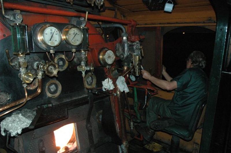 Five years since the last night runnings of steam on Spoornet metals, but<br />April 26th saw the return, with a Rovos Rail dinner train around the<br />Pretoria city complex.  Here we see the romance of night workings, the glow<br />of the fire, the driver watching the