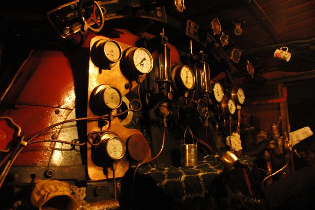 And the gentle hum of the dynamo, the siss of steam, and the soft glow of cab lighting, falling softly on the array of cab controls and gauges, creates a perfect setting for the night shift. Awaiting her next move, the engine stands, simmering away. 25NC 3442.