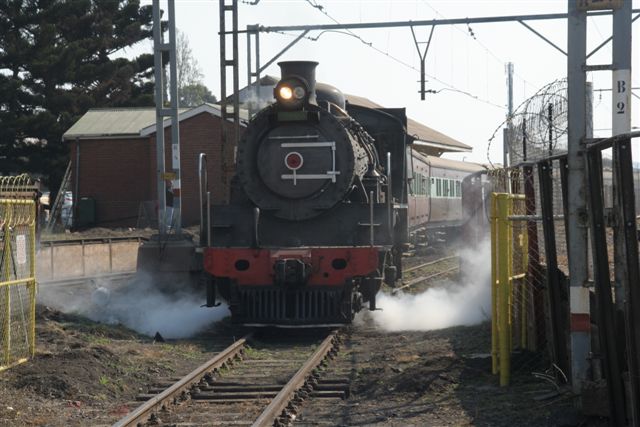 First departure - with cocks open, 3664 steams out the main gate.