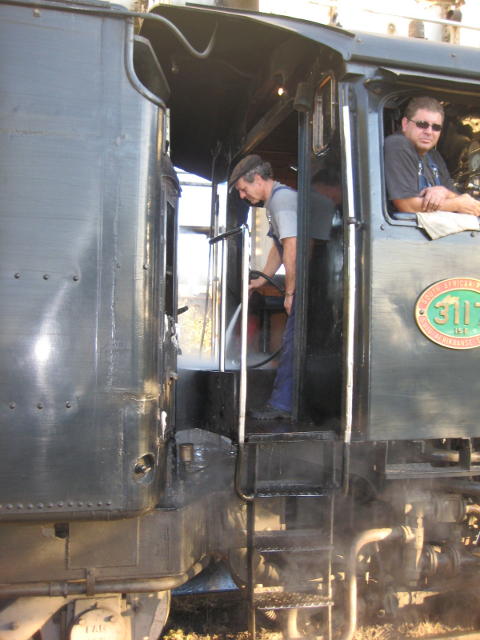 Nathan washes down the footplate with the spray pipe while Gabor looks on
