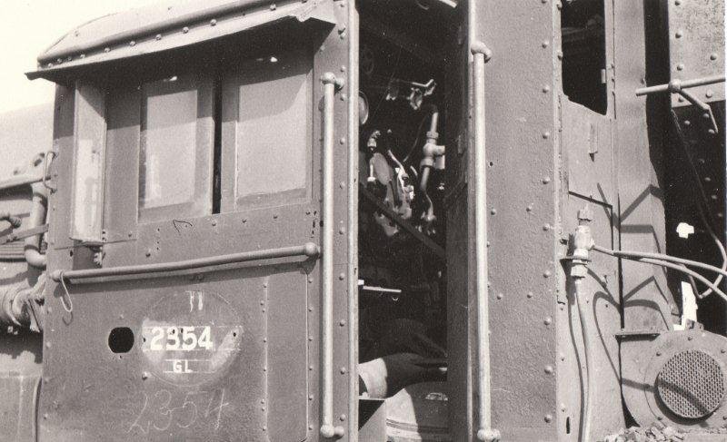 Withdrawn class GL garratt at Greyville. Of interest is the cooling fan fitted to the rear of the cab. These locomotives worked in the heat of Kwa-Zulu Natal. The bent wire hook on the outer cab handrail bears testimony to many a canvas covered water bottle swinging in the breeze. The locomotive had a Duplex mechanical stoker which fed small coal nuggets via twin feeds into the firebox. 1969