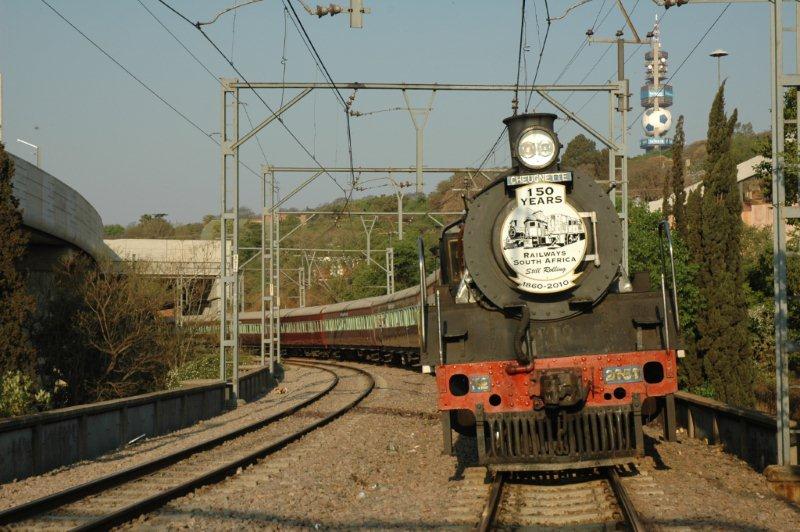 The commemorative headboard really looks great as 2650 waits for signals. The Telkom tower with World Cup soccer ball on, the Gautrain track bridge and the UNISA university all look on at railway history