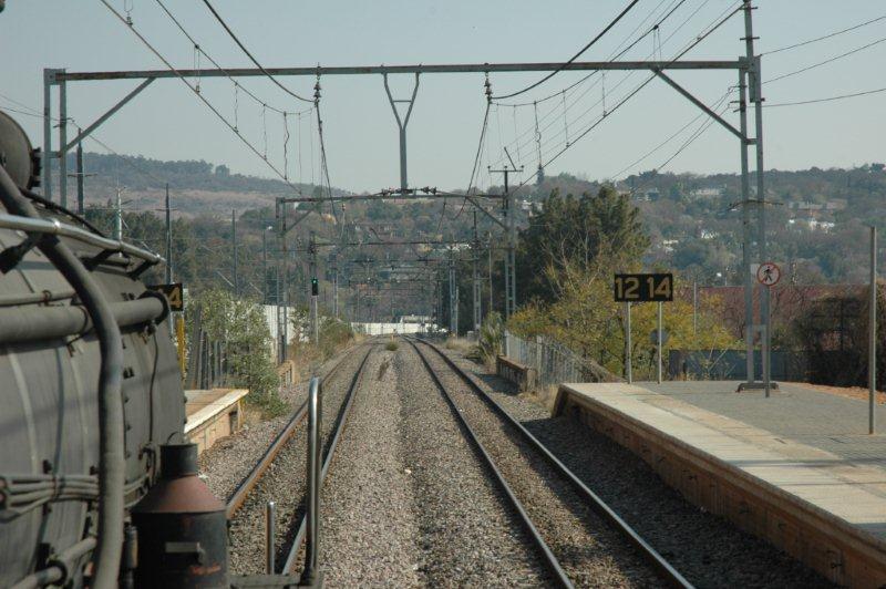 Heading towards Pretoria at Loftus Verseveld Station, the GAUTRAIN can be seen in the background negotiating the curve just behind their concrete walling.