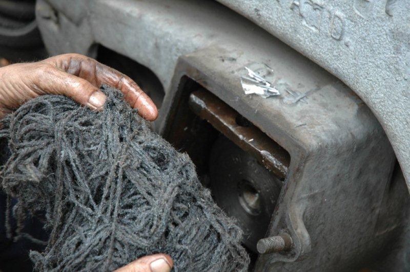 The wool packing is removed to take out the damaged pieces of the white metal bearings. A sliver of this bearing can be seen on the top of the axlebox.