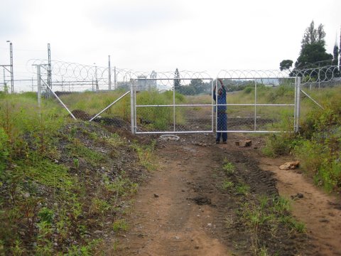 A worker puts the finishing touches to the gate across the track bed at the western end of the site