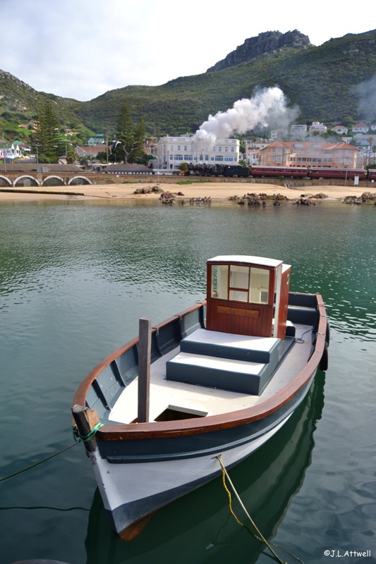 After a brief stop at Kalk Bay station, 879 storms out the station and crosses the small viaduct that runs parallel to the local harbor.
