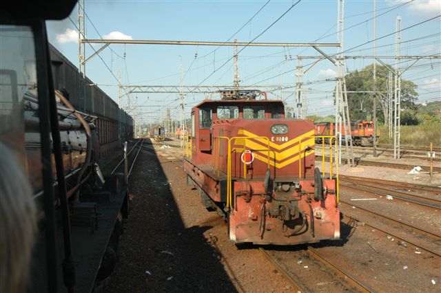 Shunt loco class 8E at Capital Park electric depot looks on as the 19D rolls past