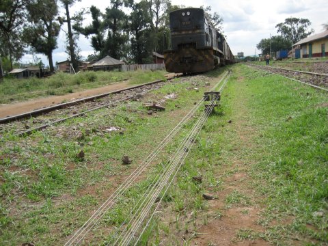 The wires controlling signals and points are clearly visible, while 9322 marshals a train of vans loaded with cement in the background