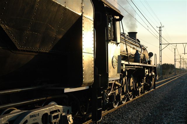 Steam at sunset. The final coat of sunset paint is laid upon the sleek boiler lines of 19D 2650, as she waits for the green light on the approaches to Koedoespoort station. The &amp;quot;Dolly&amp;quot; was returning from a successful FOTR trip to Cullinan.<br /><br />Phot