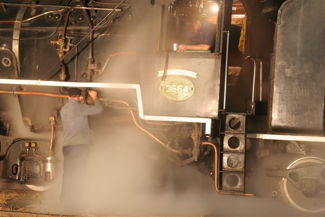 John oils the locomotive while Gabor is busy on the footplate