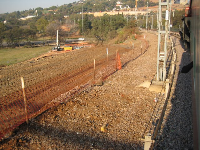 3664 has just hauled her train through Pretoria Station and now parallels the Gautrain development