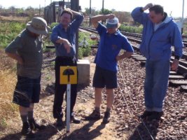 A bunch of idiots (l to r John, Courtney, Nathan and Chris) examining a sign prohibiting the growing of magic mushrooms on Spoornet property<br /><br />Photo by Mike Haslam (?)