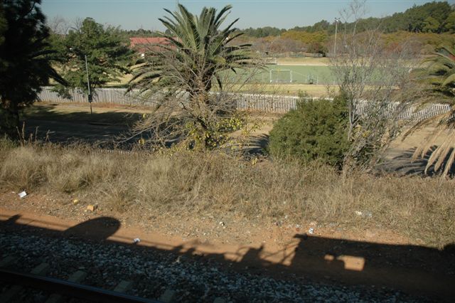 School days, sitting by this same lineside at 06h00 awaiting the arrival of the trains from Komatipoort and Lourenco Marques. Now the shadow of the class 24 brings those cinders to life as the Tshwane Xplorer rolls past the Pretoria Boys High School sports grounds as she heads Eastwards