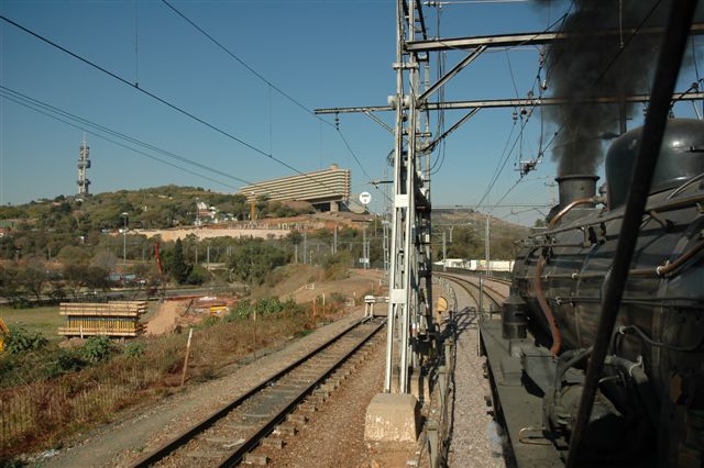 With the UNISA building overlooking the changing Pretoria rail scene, we see on the left a large amount of earthworks and construction going on for the future Gautrain. 3664, the class 24, purrs past as she takes her monthly Tshwane Xplorer set on its city circumference.
