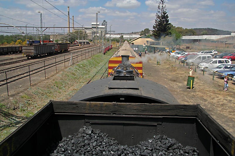 Rubbish bin tastefully framed by the train and some cars...