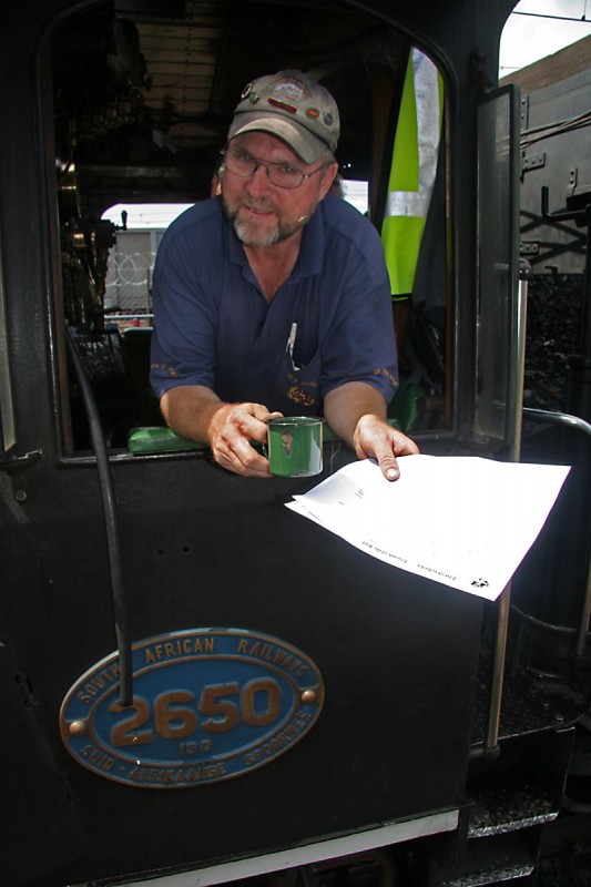 John enjoys a mug of tea whilst pretending to read a blank sheet of paper