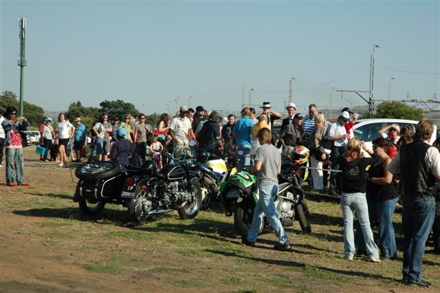 Queue-waiting passengers get the chance to admire some motor bikes