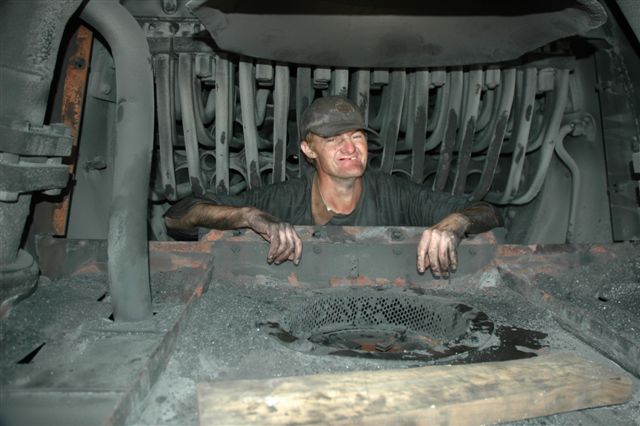 Adriaan "Spikkels" De Beer, inside the smokebox of 19D 2650, prior to having a boiler washout. There are two washout plugs on the lower tubeplate that will be used to rinse the boiler barrel with high pressure water. Of interest is the smokebox layout, with the spark arrestors and baffle plates removed. The "hole" in the foreground is the blast pipe area for exhaust emission from the cylinders, and you can clearly see the conical spark arrestor, slightly clogged up. The elements can be seen in the background, in which the steam is superheated before entering the header and then through the branch steampipes (pipes on both sides of the smokebox) to the steam chest and finally exhausting. Interesting, is it not?!