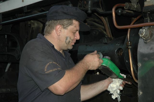Dirty Driver: Traditional servicing of a steam locomotive carried out by Shedman Gabor Kovacs. The 15F needs the "motion lotion" to keep running smoothly.