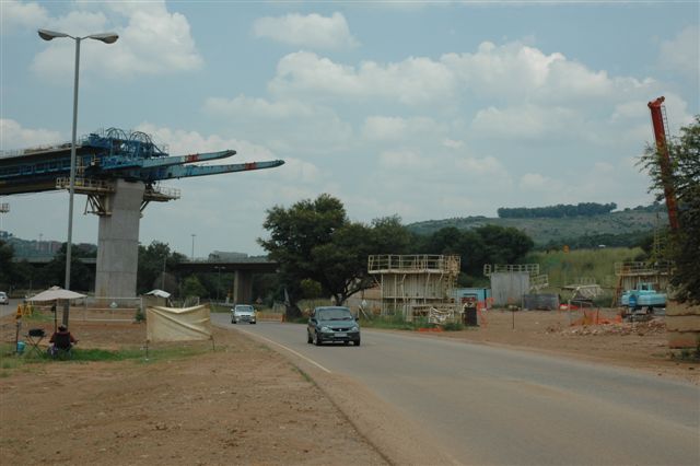 The Gautrain rail bridge about to span the Eufees road in Pretoria. In the background is the road bridge whilst behind that is the main line to Joburg, rail bridge. It was in this area in the early days that the horseshoe curve out of Pretoria station ran, and there is still sign of an old bridge in the undergrowth, to the left of this location